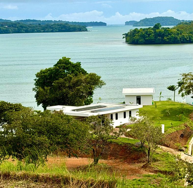 a white house on a hill next to the water at Villa Sea La Vie in Boca Chica