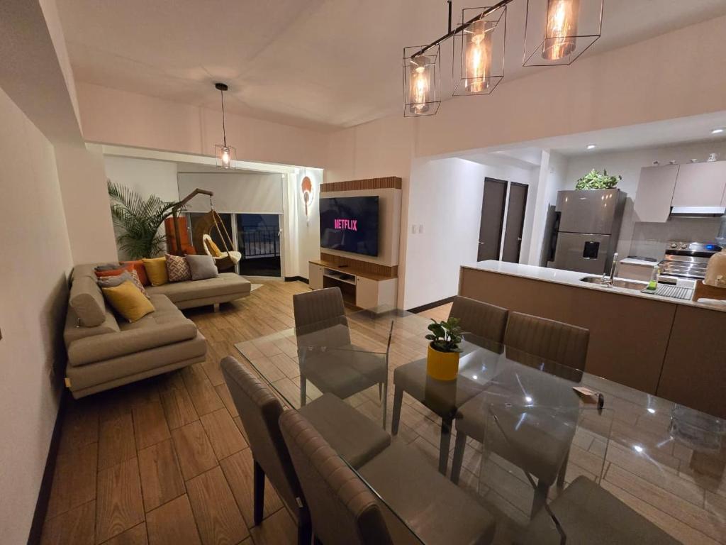 a living room with a dining table and a kitchen at Apartment in Xela Quetzaltengo Interplaza hogar calido in Quetzaltenango