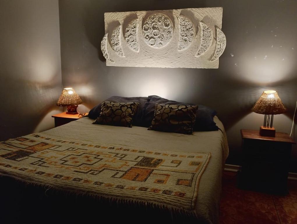 a bedroom with a large bed with two lamps at China 18, Coquimbo in Coquimbo