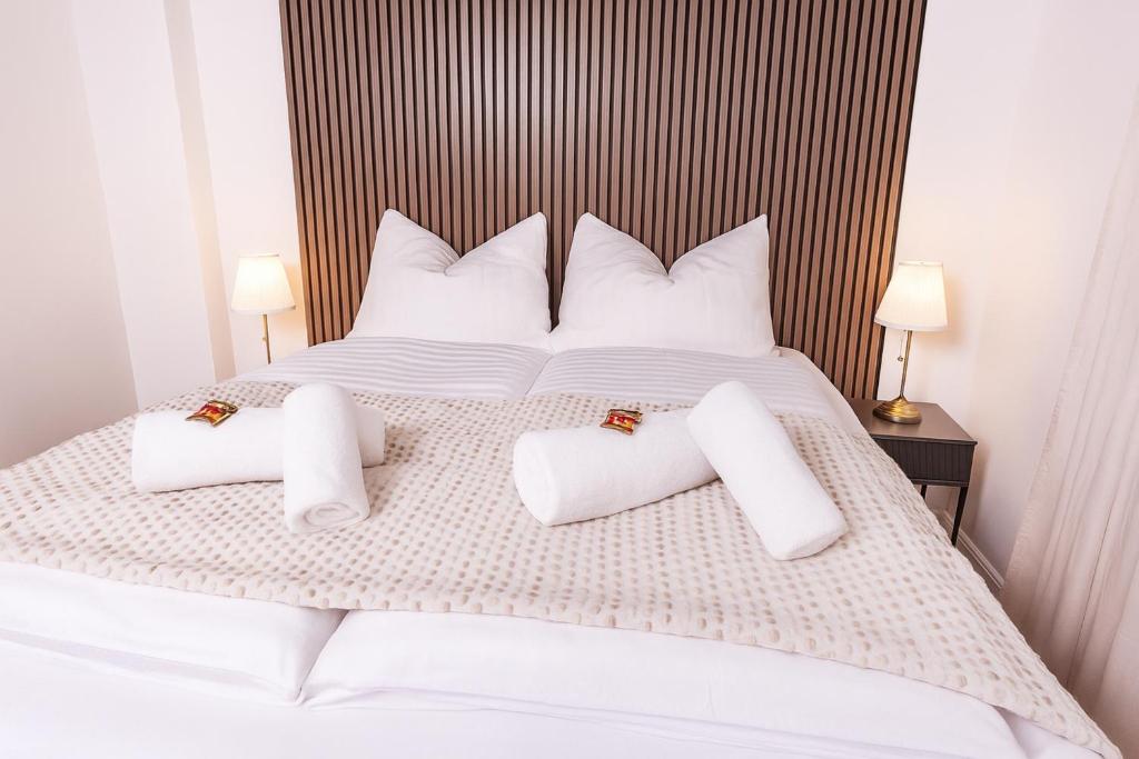 ein weißes Bett mit weißen Kissen darauf in der Unterkunft NUIT Apartment - HBF, Zentral, Helios-Klinik, Messe Düsseldorf 19 km, NEU in Krefeld