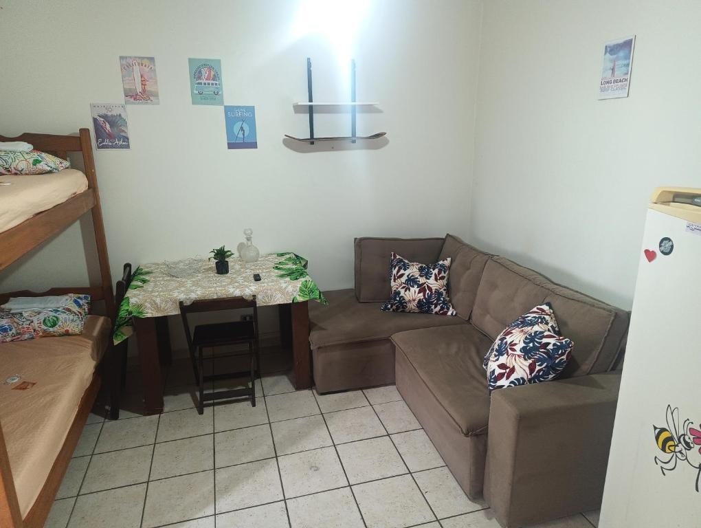 a living room with a couch and a table at Pousada Praia Grande Apartamento Familiar in Praia Grande
