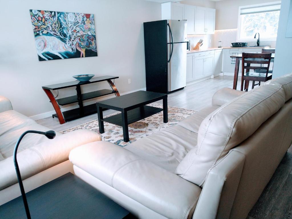 ein Wohnzimmer mit einer weißen Couch und einer Küche in der Unterkunft UofA Bike Lane-Train-Bus- Southgate Mall, Cental in Edmonton