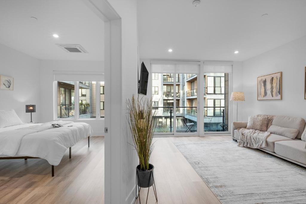 een witte woonkamer met een bed en een bank bij Luxury 1br Getaway - Modern Stylish & Great Area in Philadelphia