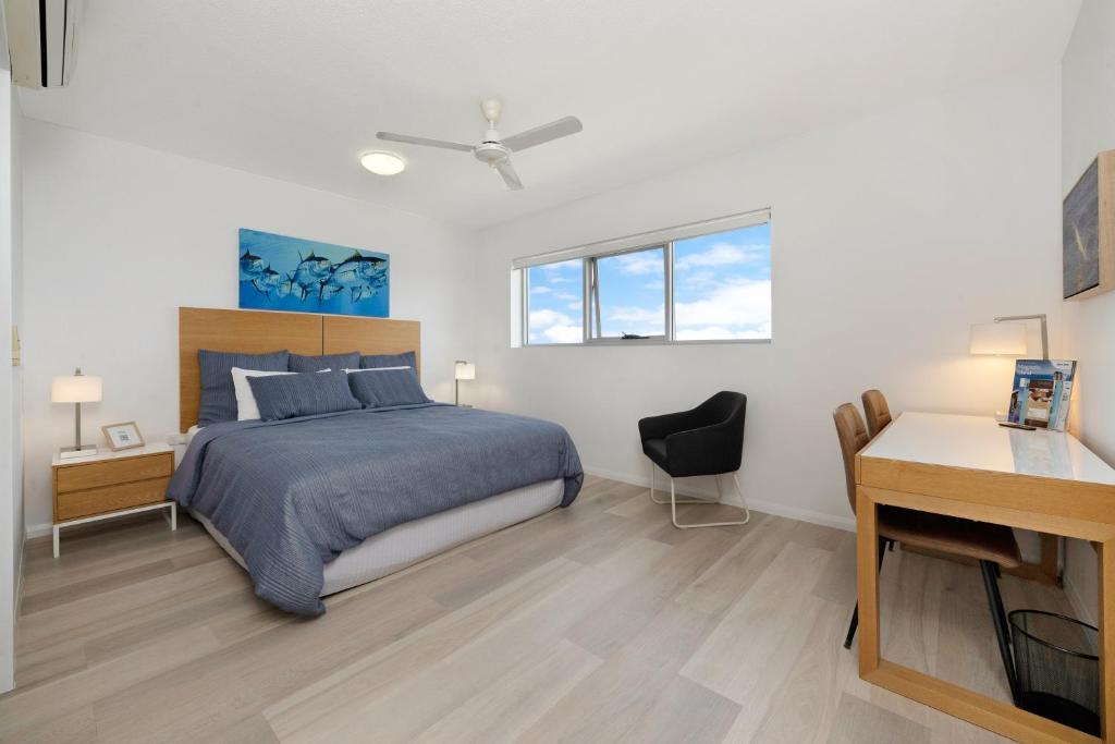 een slaapkamer met een bed en een bureau en een bureau bij Marina View Studio Apartment in Townsville
