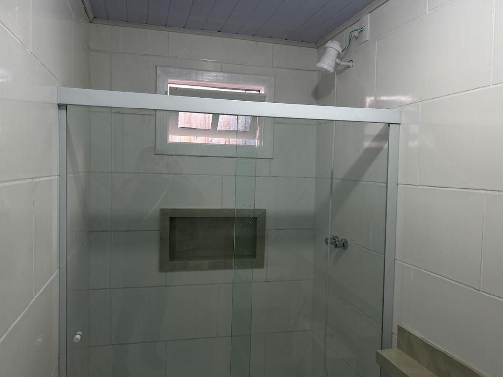 a shower with a glass door in a bathroom at Casa Aconchegante em Biguaçu próximo às praias in Biguaçu