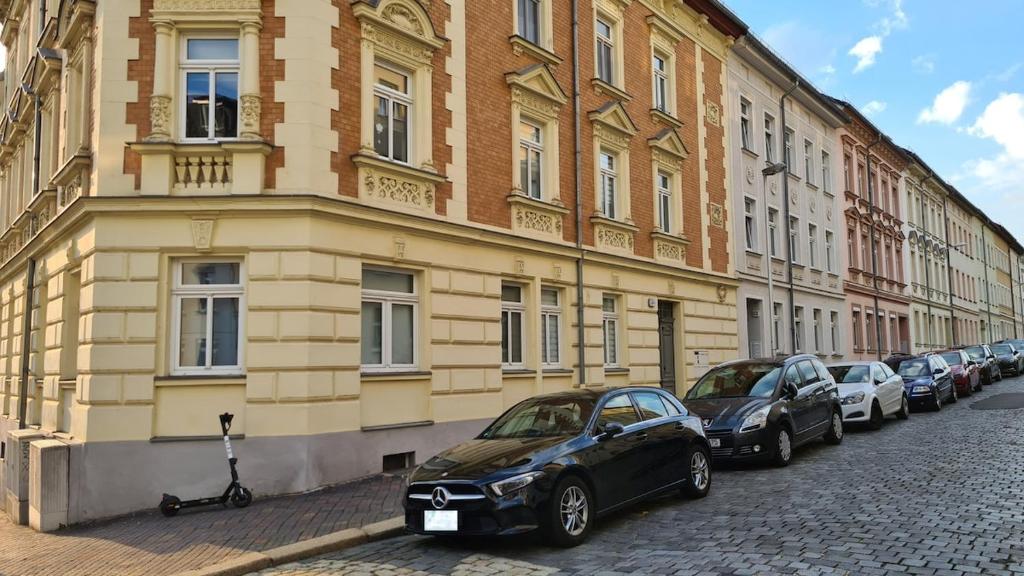 ゲーラにあるHelles Maisonette Apartmentの建物前に停車する車列