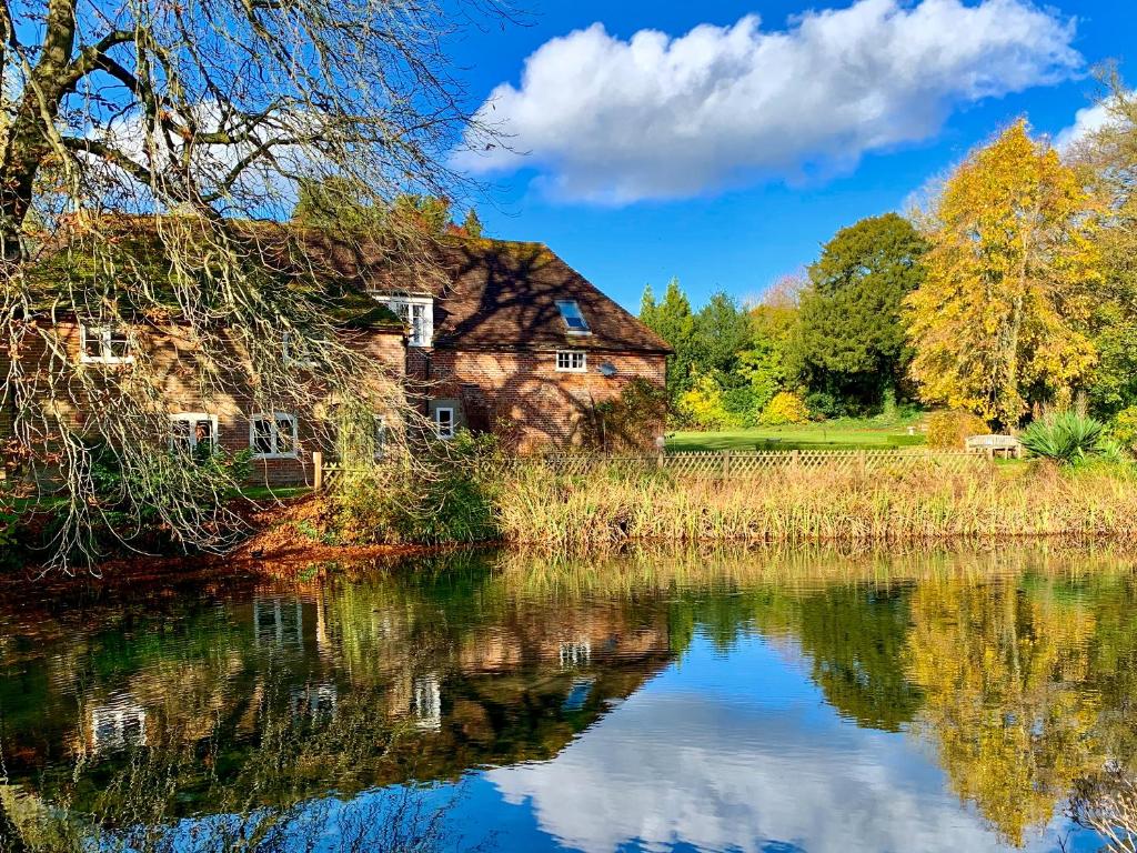ein altes Haus neben einem See in der Unterkunft Moorhen Cottage in Hollingbourne