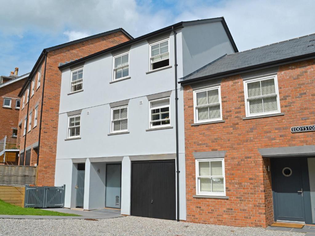 a white house with a red brick building at Eddystone Row 2 in Salcombe