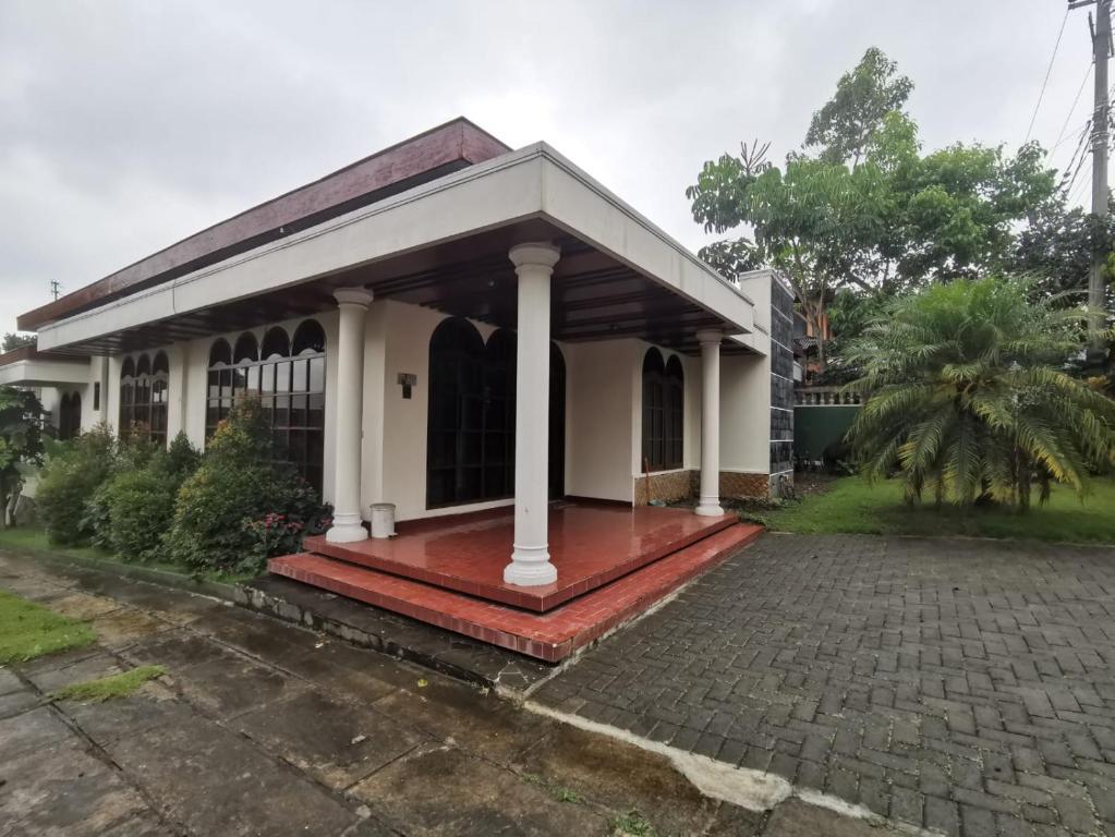 a small white house with a red porch at Villa Graha Permata 1 in Batu