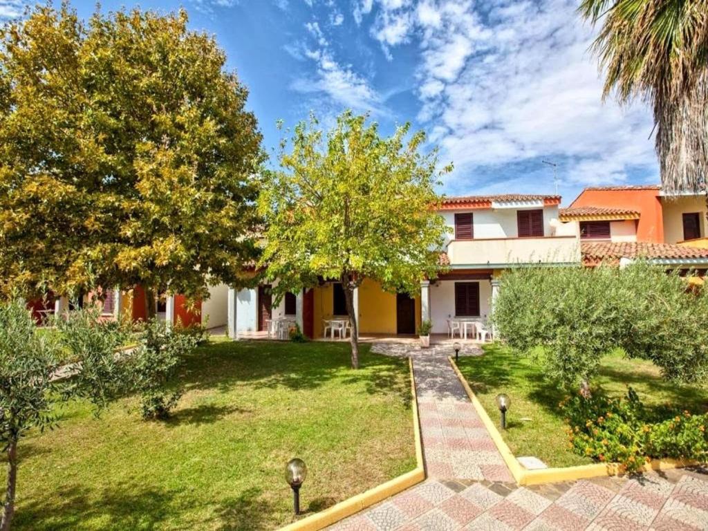 an exterior view of a house with a yard at Apartment with Pool and Private Parking in Porto Ottiolu