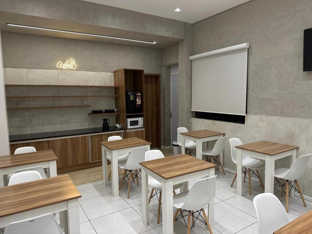a restaurant with tables and chairs and a whiteboard at Hotel Life Ijui in Ijuí
