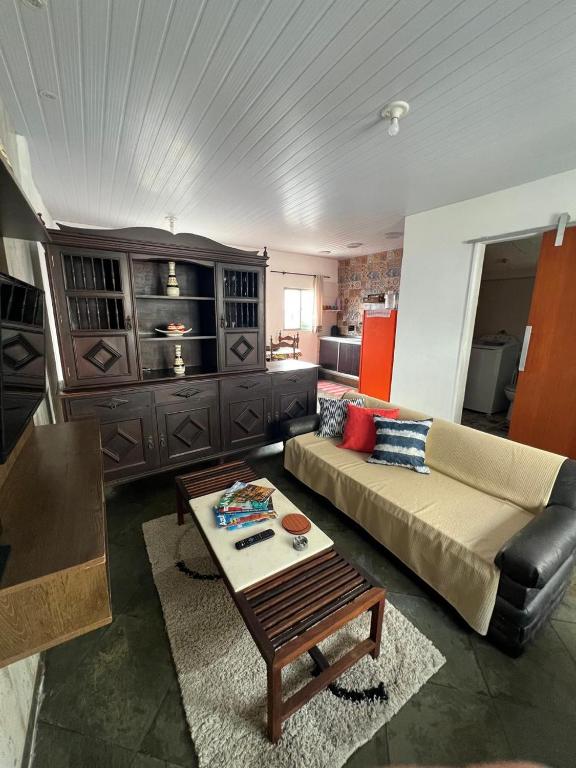 a living room with a couch and a table at Apê da Lêda Loft - 400m da Praia do Forte in Cabo Frio