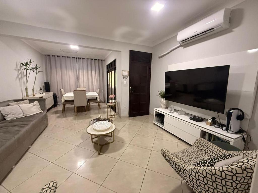 een woonkamer met een bank en een flatscreen-tv bij Casa Marambaia in Água Boa