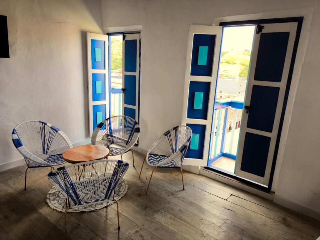 een tafel en stoelen in een kamer met ramen bij Hotel Colonial San Roque in San Roque