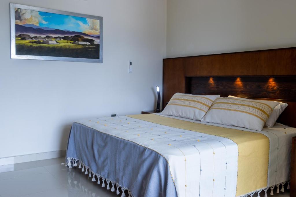 a bedroom with a large bed with a wooden headboard at Galerias Oaxaca Suites in Oaxaca City