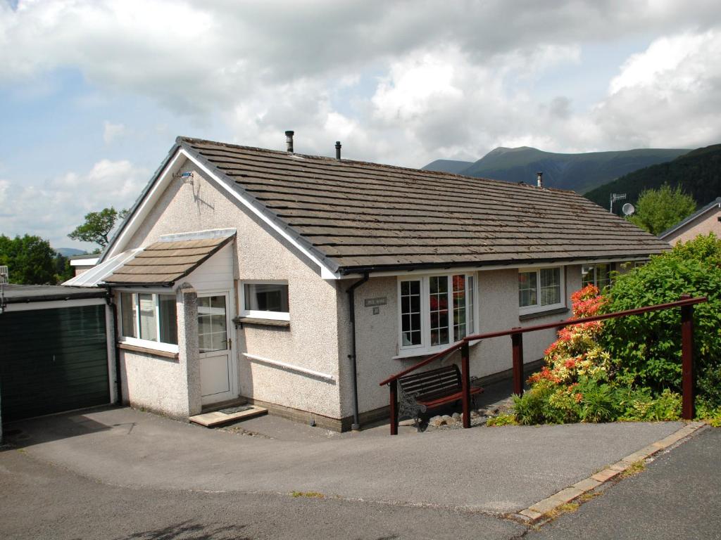 a small white house with a bench in front of it at Peel Wyke in Keswick