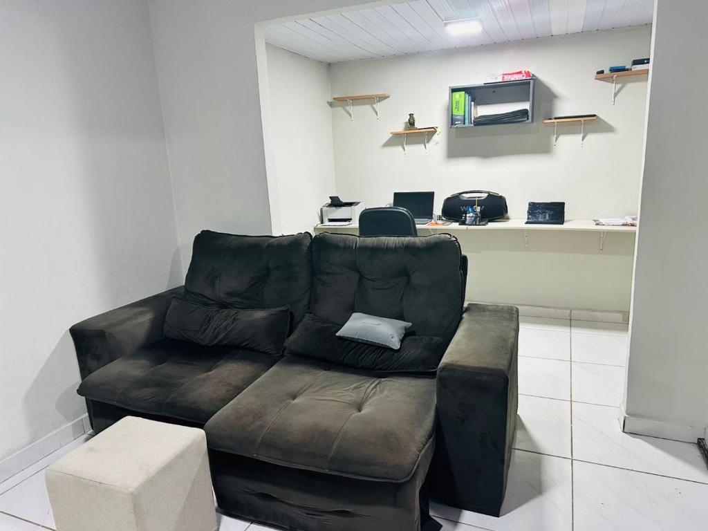 a living room with a couch and a microwave at Quarto privativo para cop 30 in Ananindeua