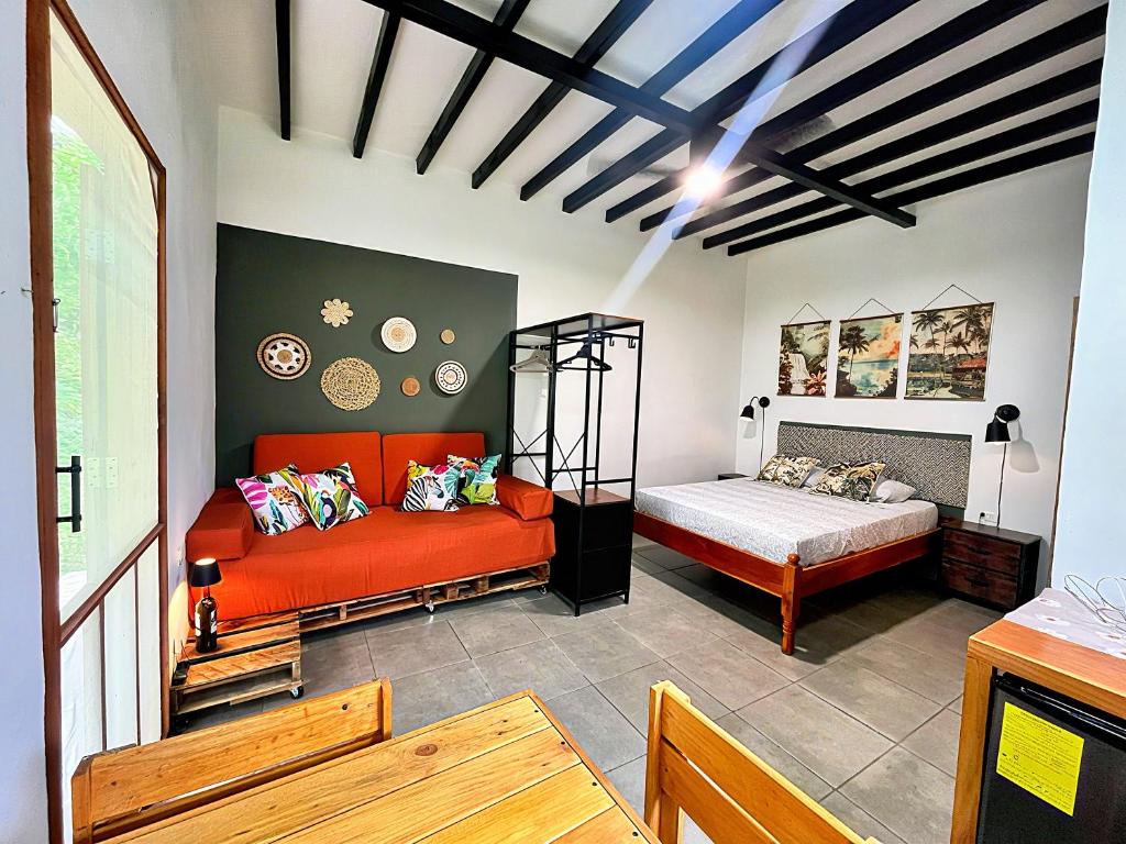 een slaapkamer met een oranje bank en een bed bij Finca Aisa -Boutique bungalows in Ometepe island in Santa Cruz