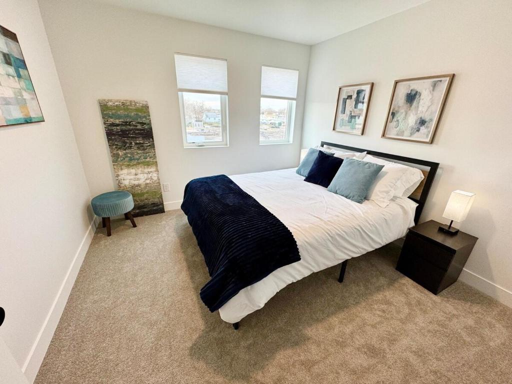 ein Schlafzimmer mit einem großen Bett und zwei Fenstern in der Unterkunft 4BR Townhome near Downtown-SLC Airport in Salt Lake City