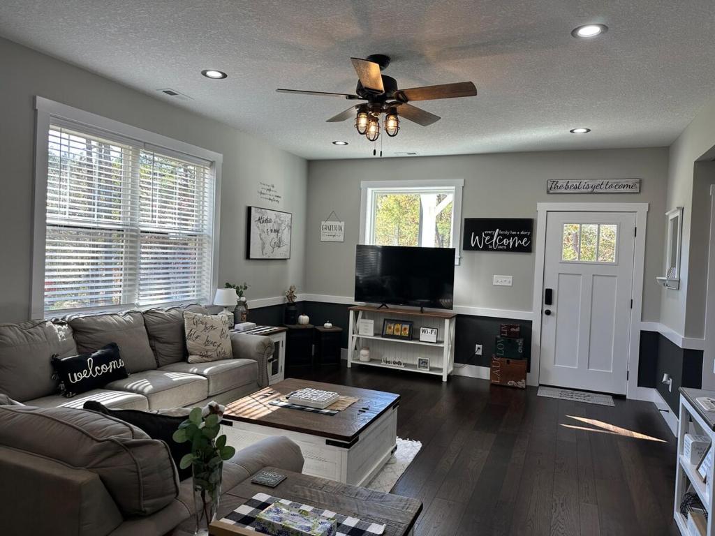 Una sala de estar con un sofá y un ventilador de techo. en Hidden Gem, en Weaverville
