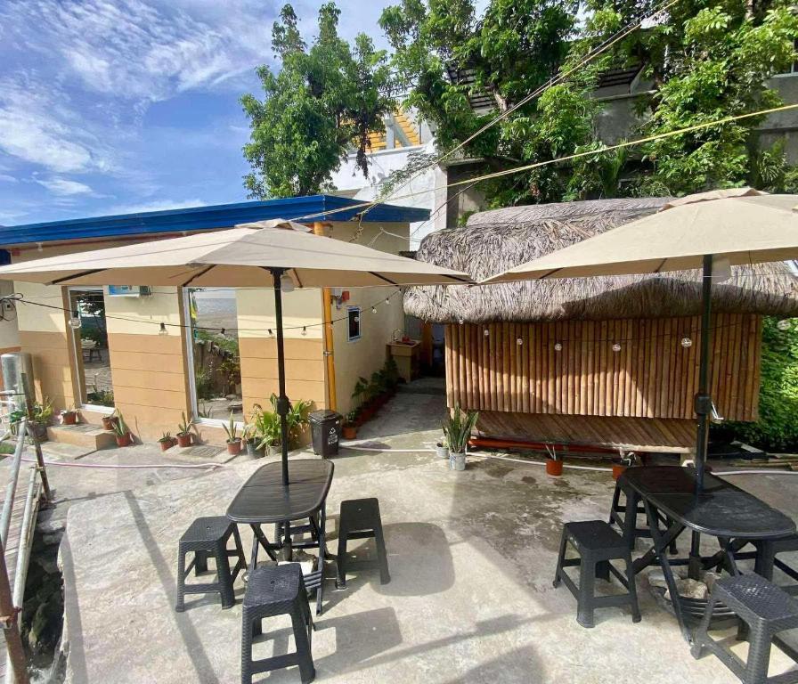 a patio with tables and chairs and umbrellas at San Juan ELYU Beachfront Cabin in San Juan