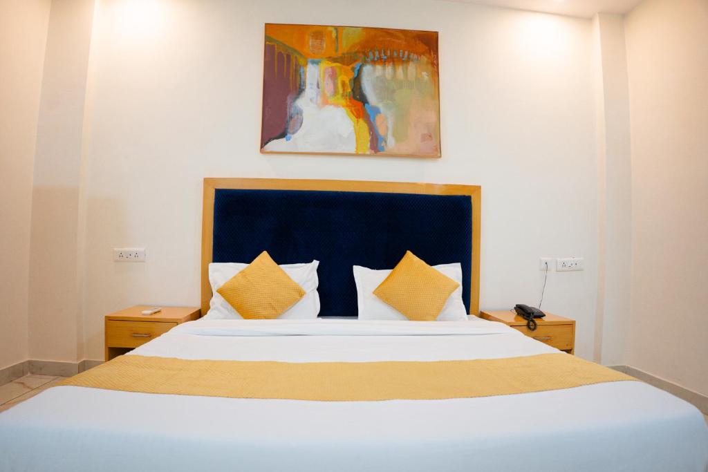 Un dormitorio con una gran cama blanca con almohadas amarillas. en The Sweven Rishikesh, en Rishīkesh