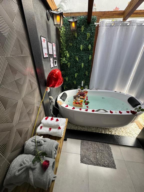 a bathroom with a tub and a green wall at Chalé Colina in Venda Nova do Imigrante