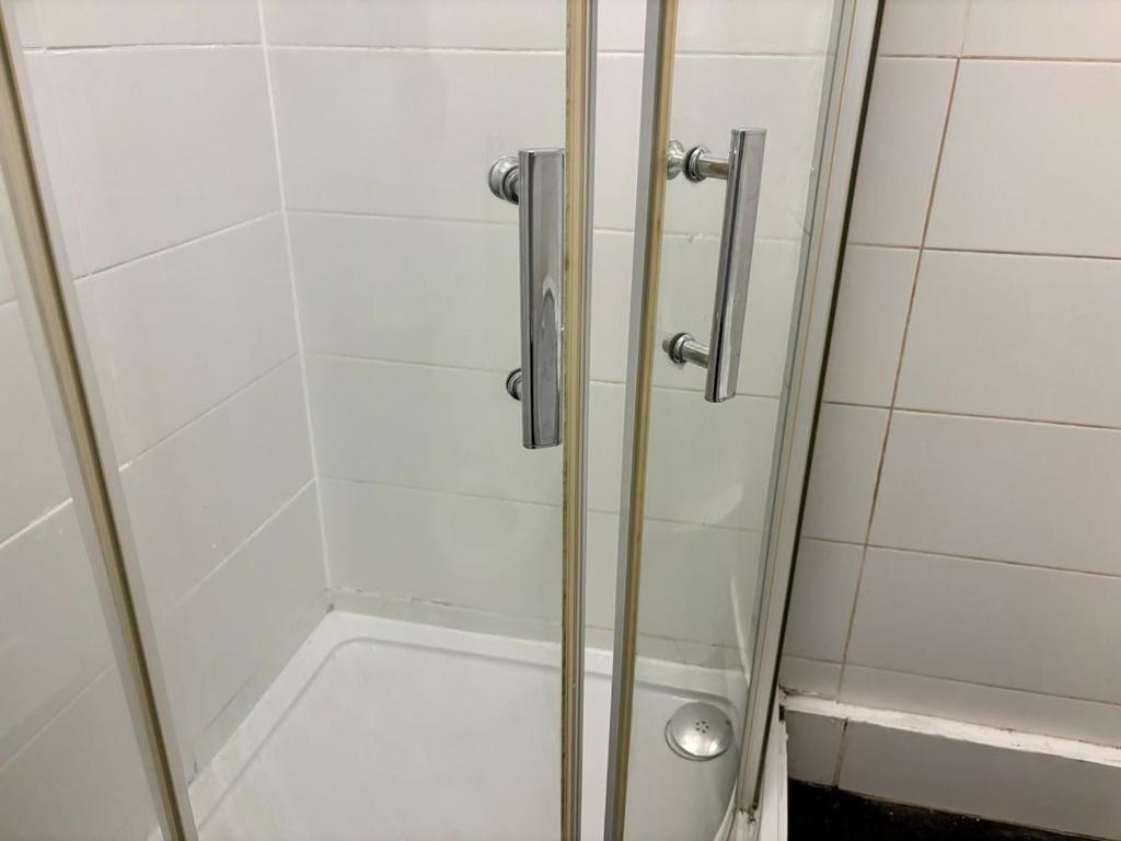 a shower with a glass door in a bathroom at Flat 9 Haden in Wolverhampton