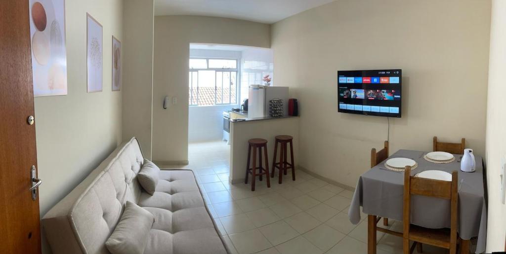 a living room with a white couch and a table at Apartamento in Viçosa
