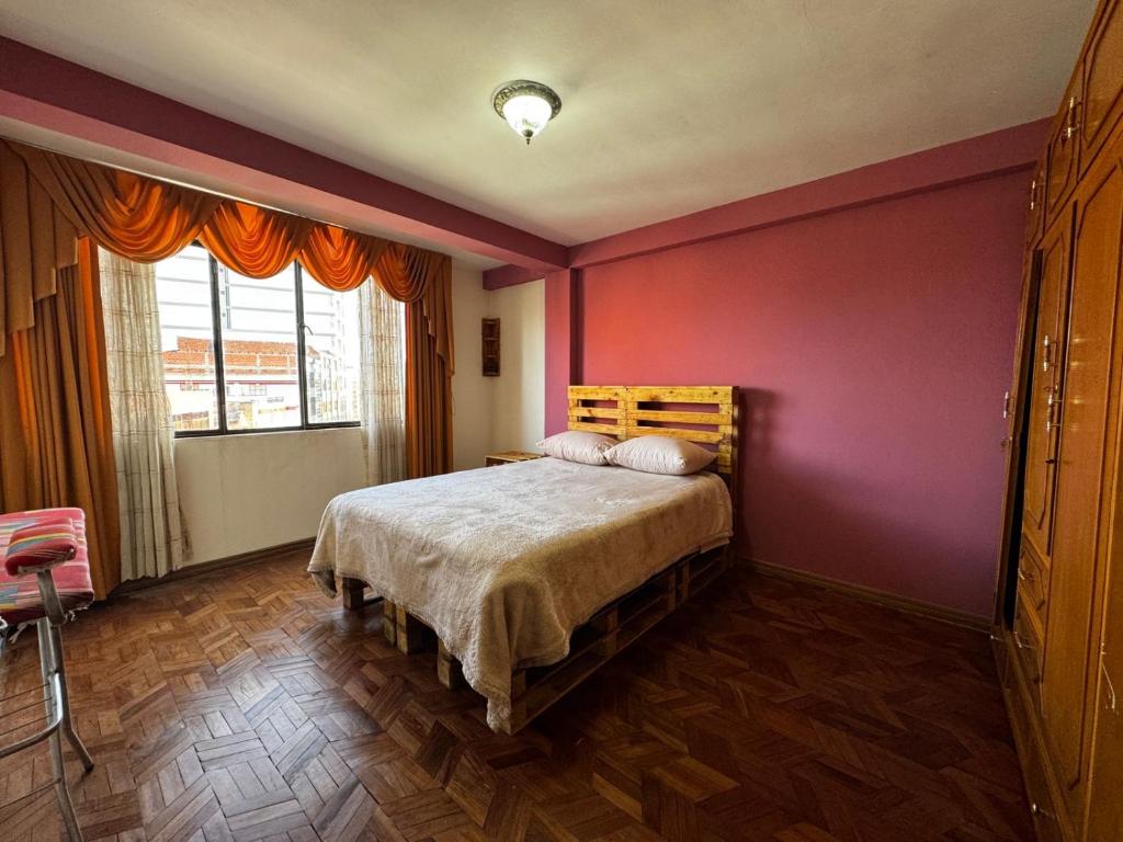 a bedroom with a bed and a red wall at Altura View Stay in La Paz