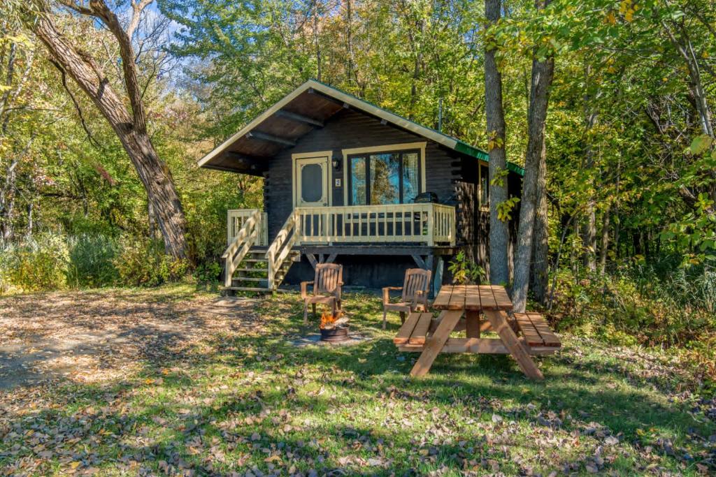 a tiny house in the woods with a picnic table at chalet 5 Domaine de l'Archipel in Sorel