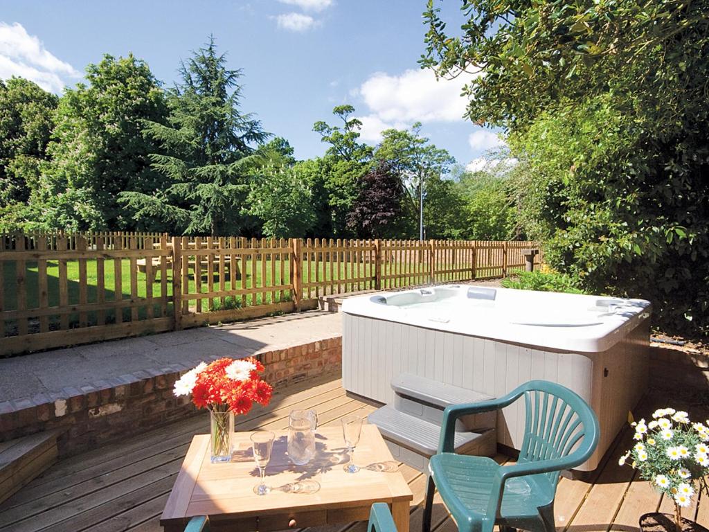 a hot tub and a table and two chairs on a patio at Salters Cottage - E5045 in Wainfleet All Saints