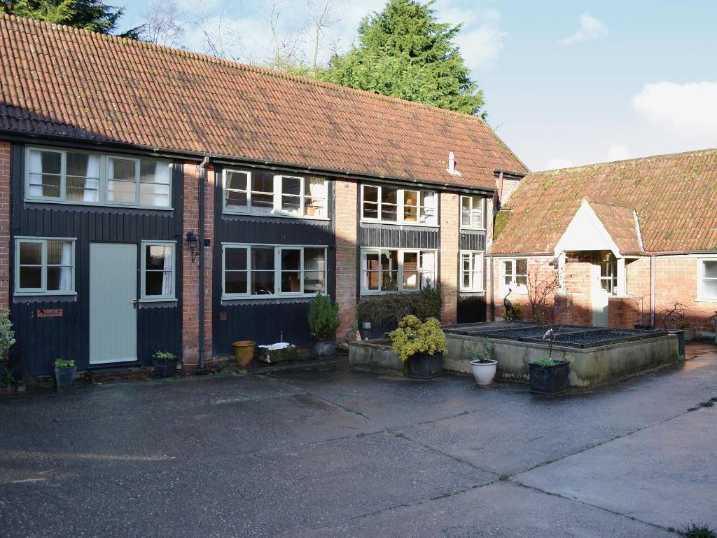 a group of houses with a courtyard in front at Bat's Cottage in Tipton Saint John