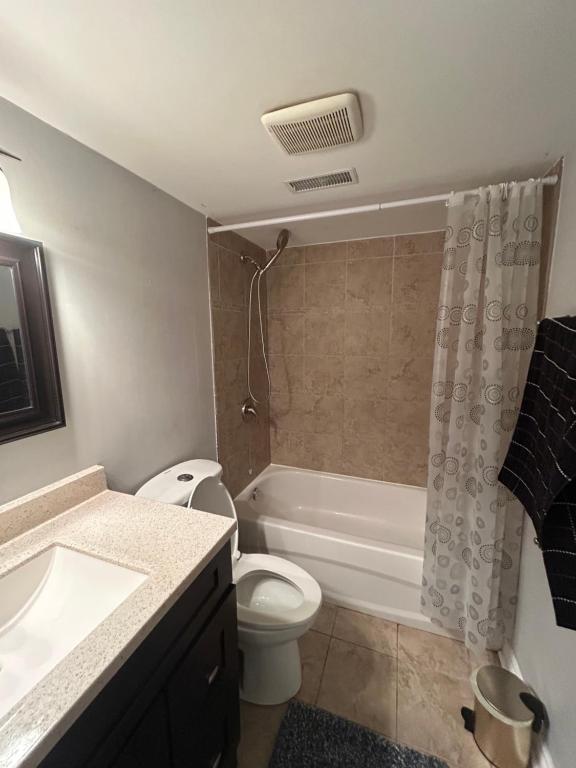 a bathroom with a toilet and a tub and a sink at Private separate entrance suite in Oshawa