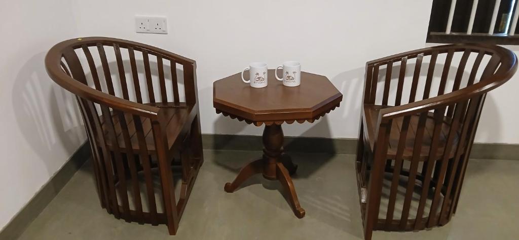 a small table and two chairs with cups on it at Randinu Villas Tangalle in Tangalle