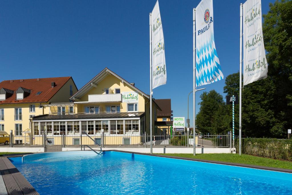 ein Hotel mit einem Pool vor einem Gebäude in der Unterkunft Landhotel Huberhof in Allershausen