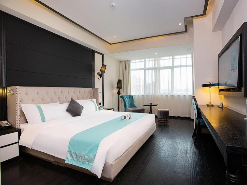 een hotelkamer met een groot bed en een flatscreen-tv bij Xana Hotelle Zhengzhou Guoji Branch in Zhengzhou
