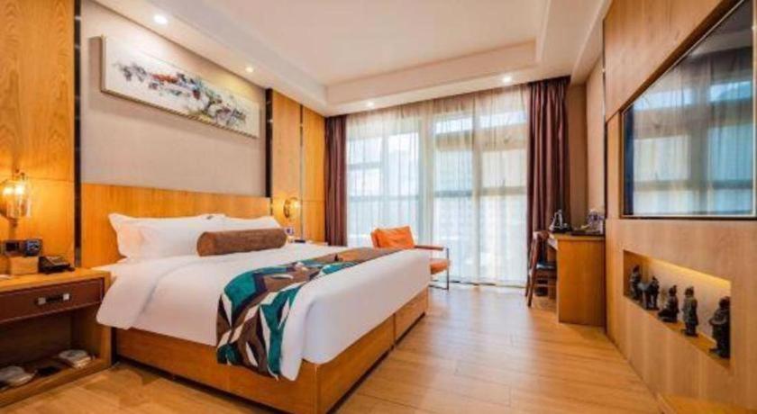 ein Schlafzimmer mit einem großen Bett und einem großen Fenster in der Unterkunft James Joyce Coffetel Xi'an Laochenggen Hongmiaopo Metro Station in Xi'an