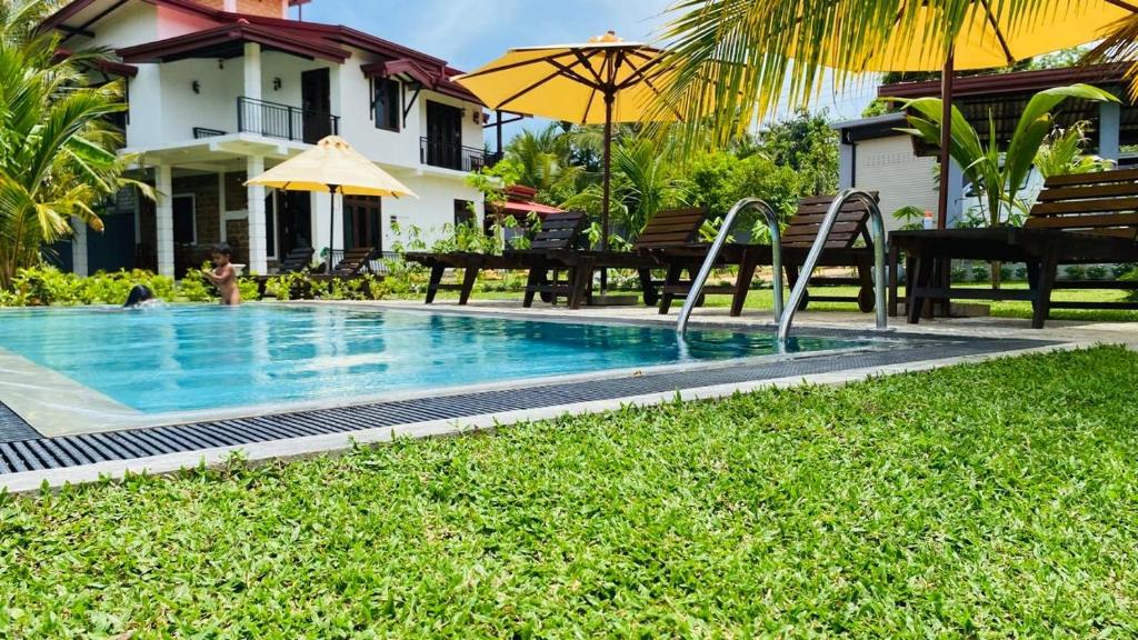 a swimming pool with a slide in a yard at Nelumbo Villa 42 - oasis of relaxations in Uragasmanhandiya