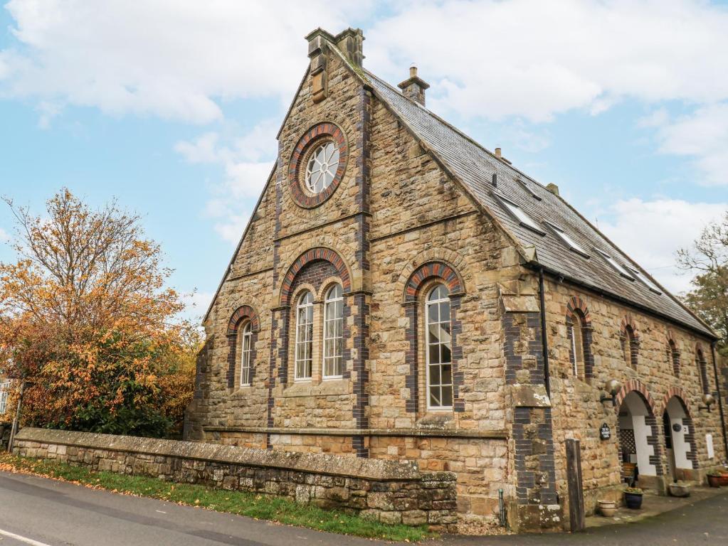 een oude stenen kerk met een klok erop bij 1 The Old Methodist Chapel in Rosedale Abbey