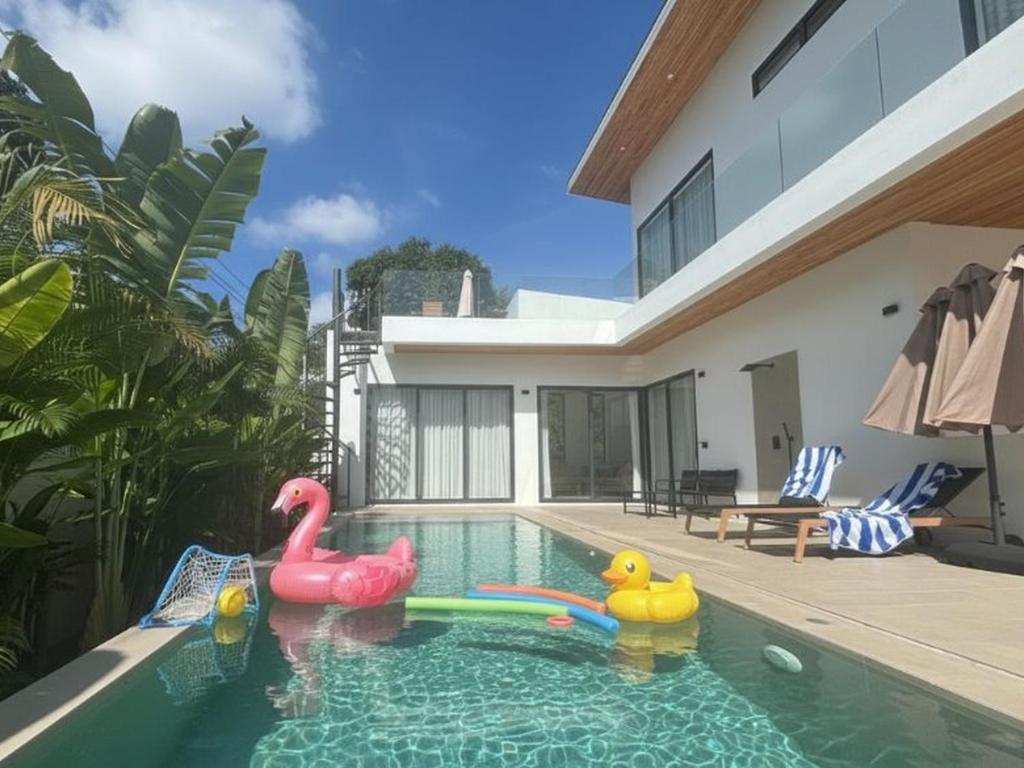 a swimming pool with two inflatable flamingos in a house at Kohkohnut villa 3BR Villa with Private Pool in Bophut Near Fisherman in Amphoe Koh Samui
