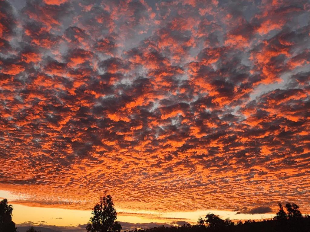 a sunset with clouds in the sky at 138 On The Bay - Sunset Bliss on the Waters Edge in Murdunna