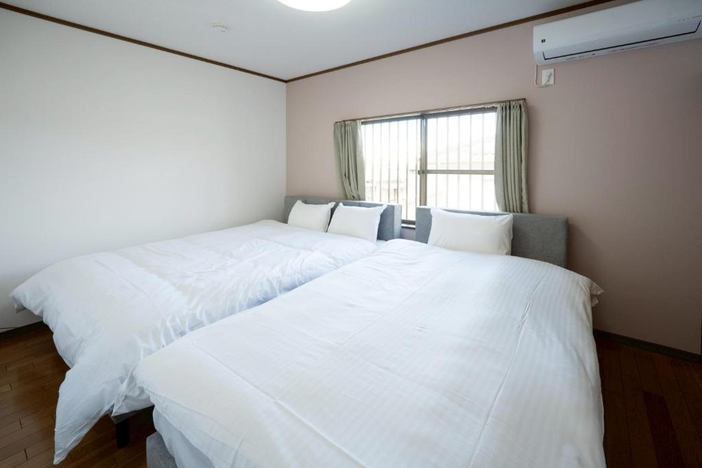 two white beds in a room with a window at 晴宿-Hareyado 