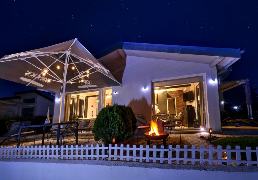 ein Haus mit einem weißen Zaun und einem Regenschirm in der Unterkunft villas 21,22 Albena sea view in Rogachevo