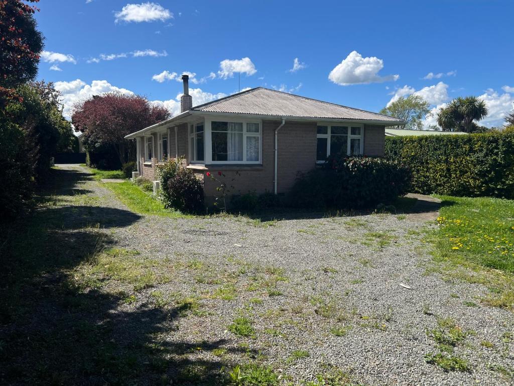 a small house on the side of a gravel road at Darfield Hotel Apartment Home in Darfield