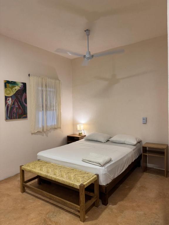 a bedroom with a bed and a bench in it at La Punta in Brisas de Zicatela
