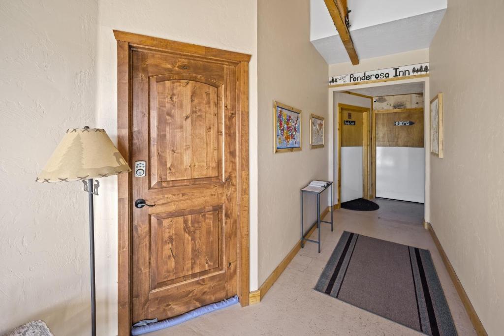 a room with a wooden door and a hallway at Ponderosa Inn in Escalante