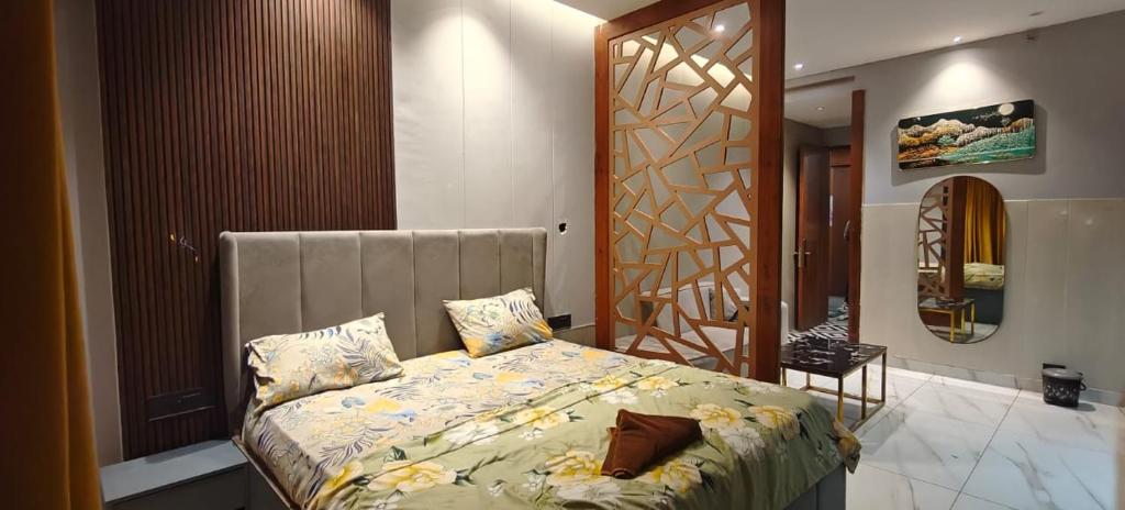 une chambre avec un lit, une chaise et un miroir dans l'établissement Blue Sapphire Forest Stays, à Ghaziabad