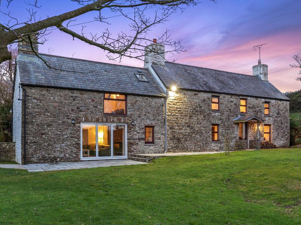 a stone house with a lawn in front of it at Morfa Ganol in Llangranog