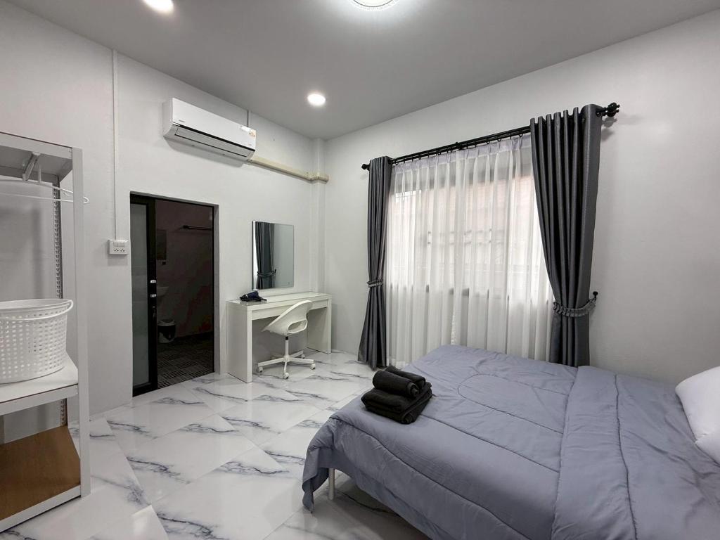 a bedroom with a bed and a desk and a window at Together Stay Home in Mae Sai